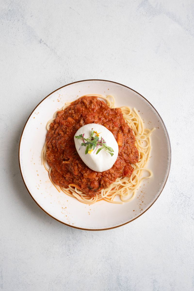 Spaghetti bolognese topped with fresh burrata